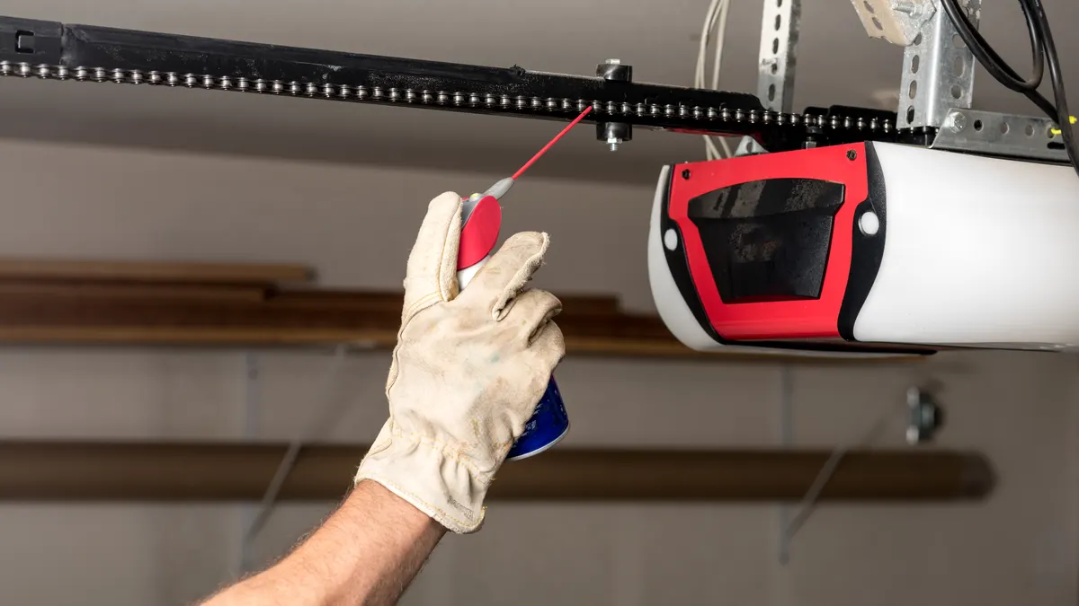 Technician lubricating a garage door opener chain